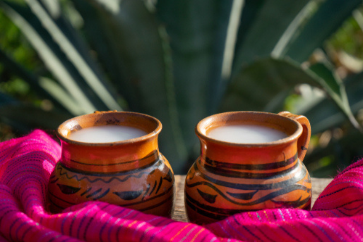 Chilled tepache in a vessel, garnished with pineapple